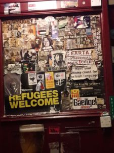 Stickers and posters on a door in a Belfast pub. Most support refugees and freedom movements around the world.